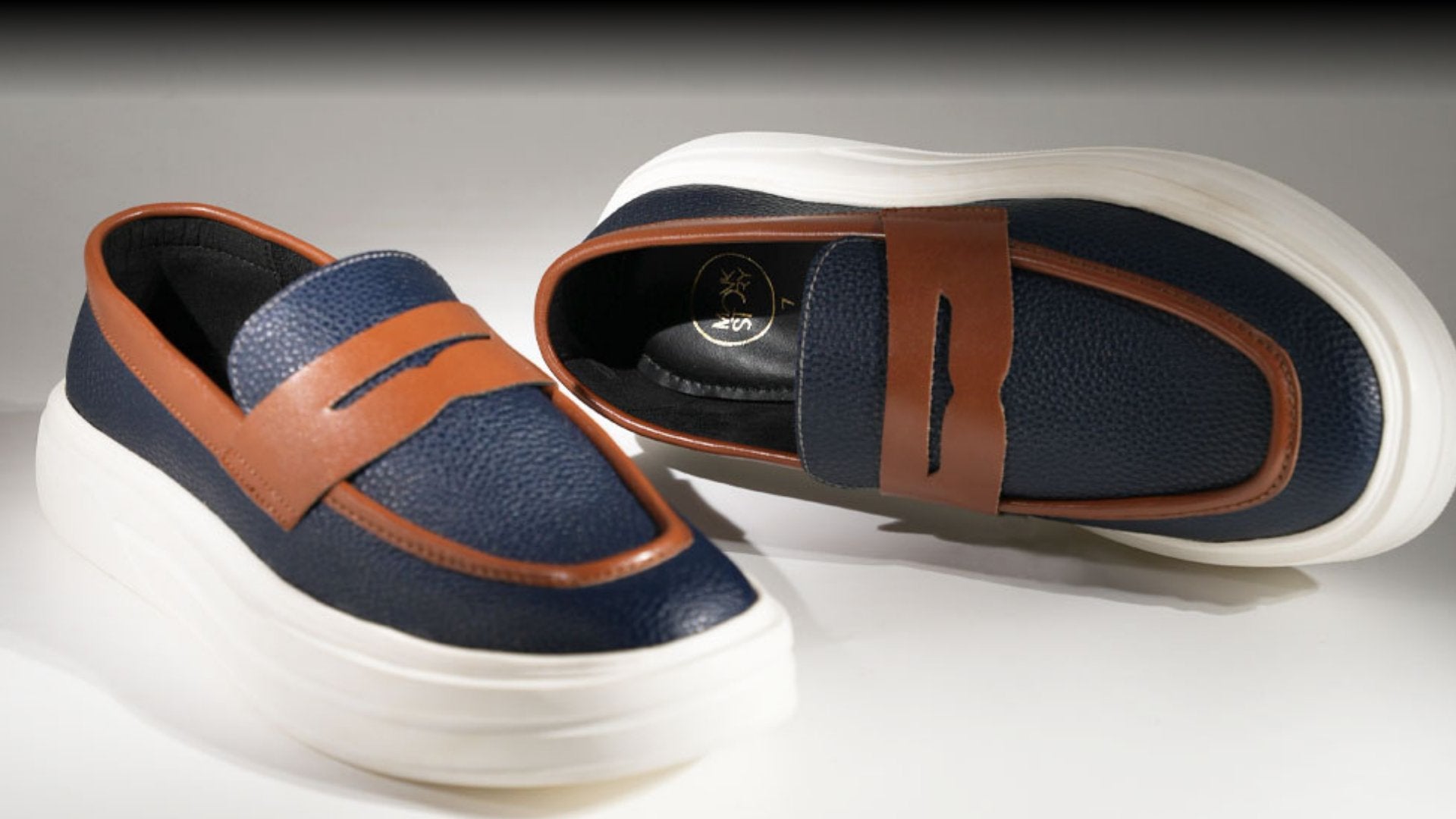 A man wearing a pair of brown shoes next to a box.