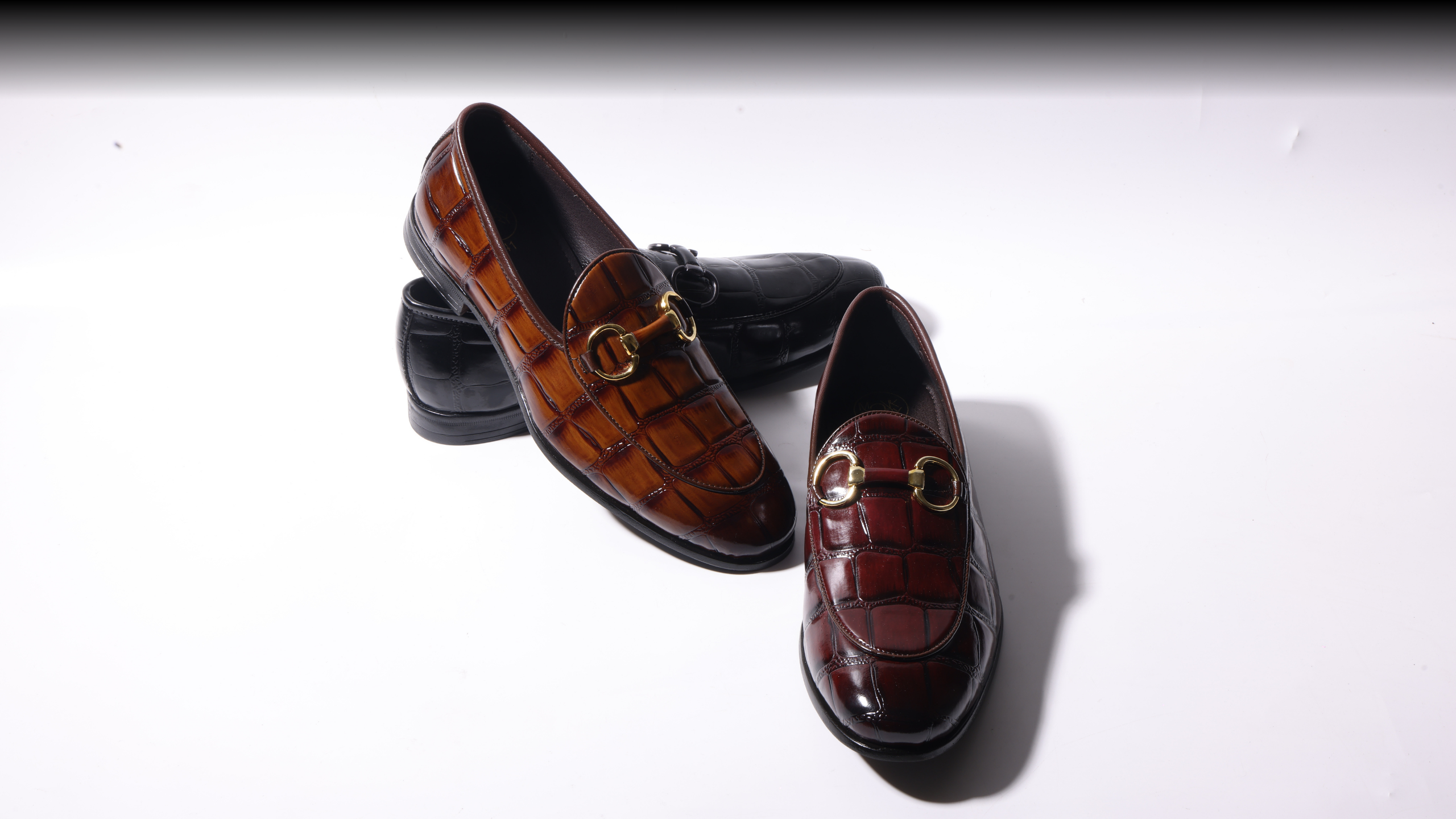 A pair of black shoes on a red background.