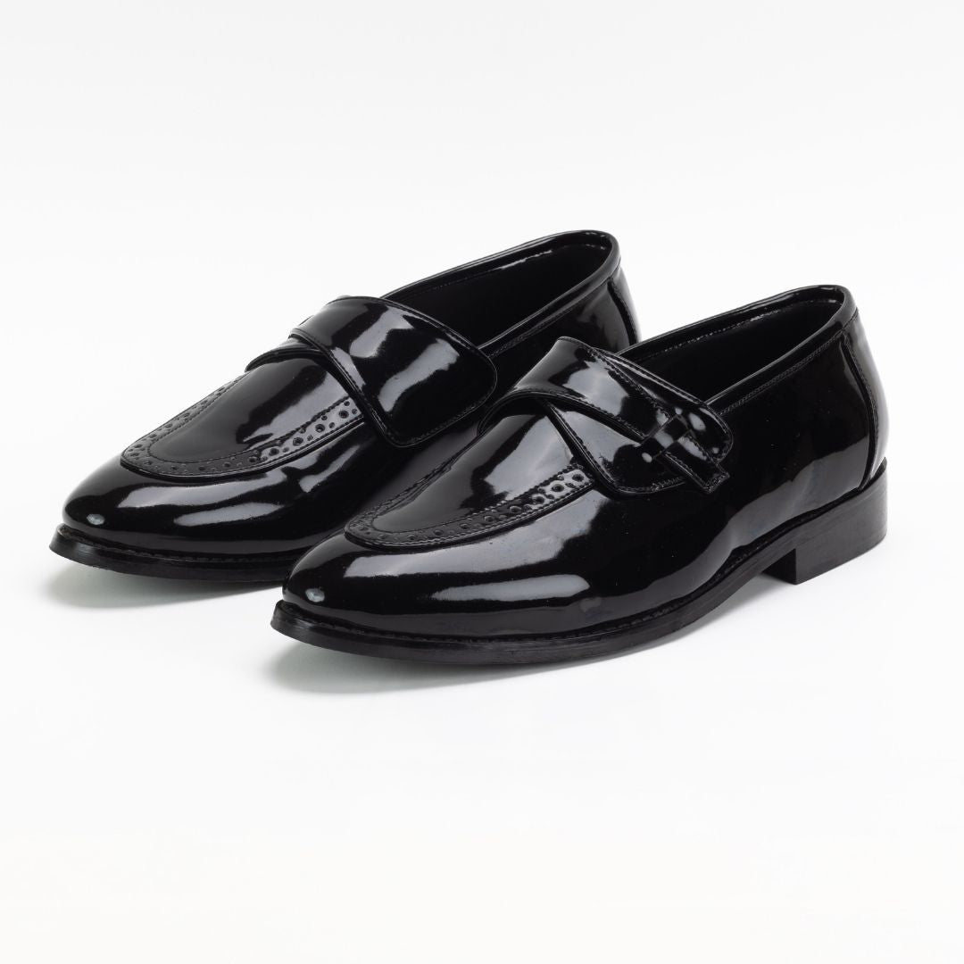 A pair of Drezzire Classic Patent Slip-Ons - Black from monkstory on a white background.