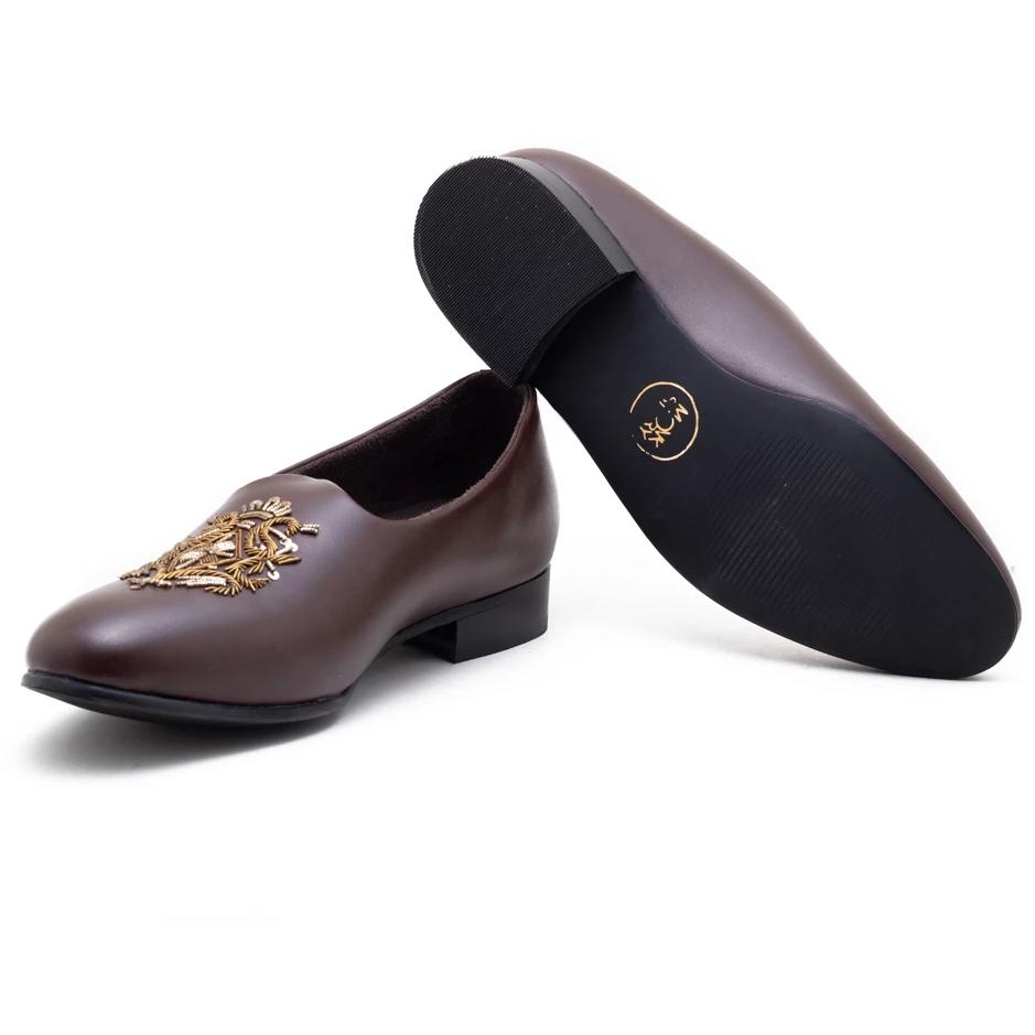 A pair of Monkstory Magenta Mojri shoes with brown embroidered designs.