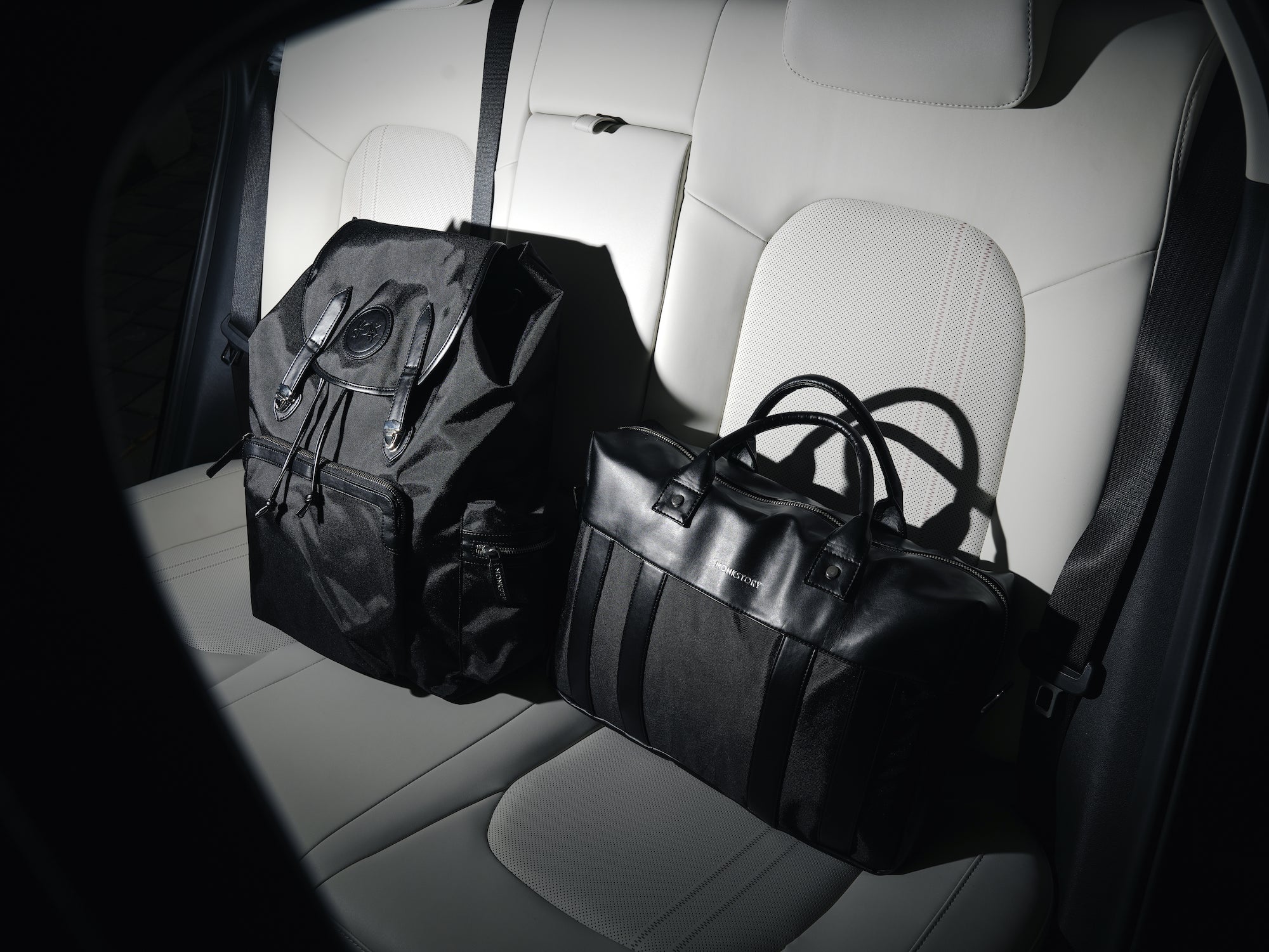 Two bags sitting in the back seat of a car.