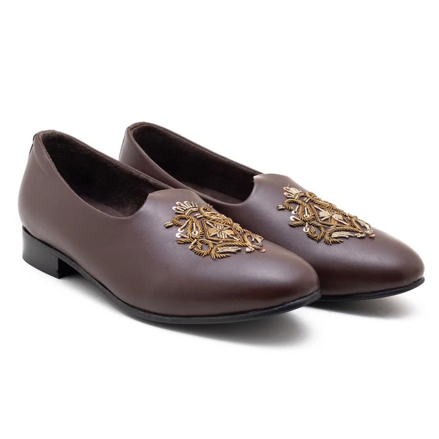 A pair of Monkstory Magenta Mojri shoes with brown embroidered designs.